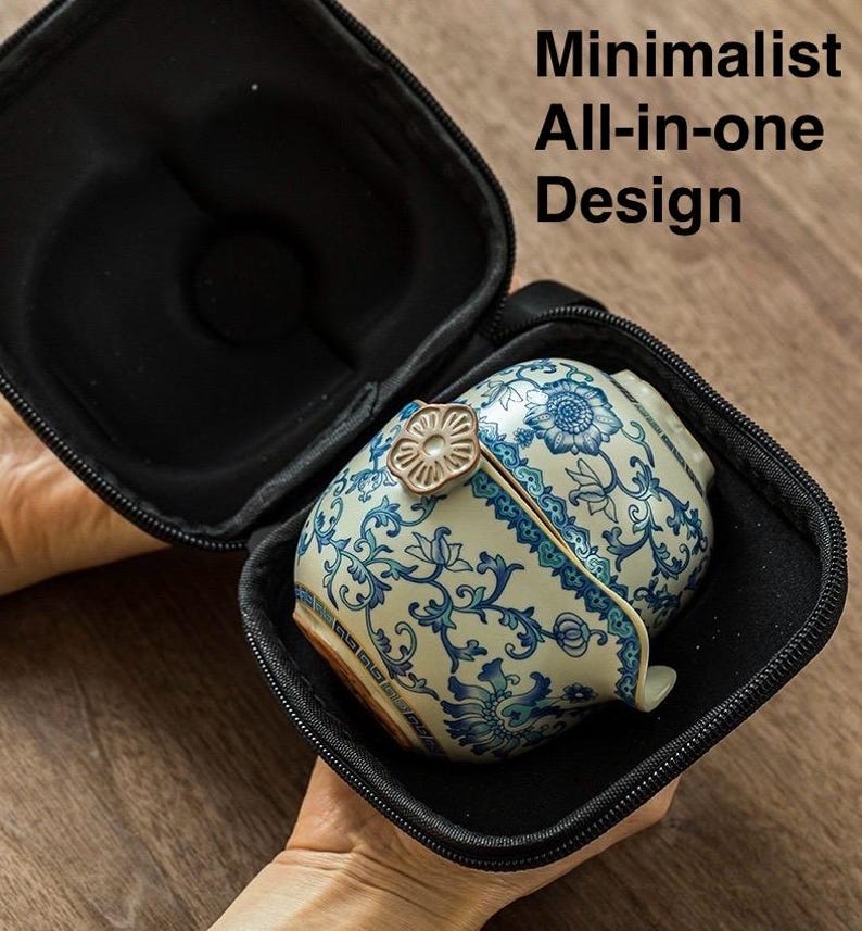 Puede incluir: Un juego de t&eacute; de cer&aacute;mica con dise&ntilde;os florales azules est&aacute; dentro de un estuche de transporte negro. El juego de t&eacute; tiene una tapa con un asa decorativa. El texto "Minimalist All-in-one Design" es visible.