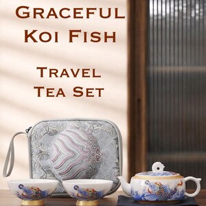 May include: A travel tea set featuring a teapot, two cups, and a carrying case. The white porcelain teapot and cups are decorated with blue koi fish designs and gold accents. The text "GRACEFUL KOI FISH TRAVEL TEA SET" is displayed.