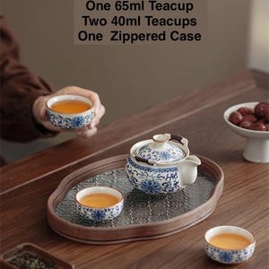 May include: A tea set with a teapot, teacups, and a zippered case. The teapot and teacups have a blue and white floral design. The text on the image says the set includes a 200ml teapot, a 65ml teacup, two 40ml teacups, and a zippered case.