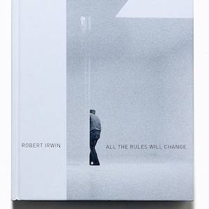 May include: A hardcover book with a white cover and the title "ALL THE RULES WILL CHANGE." The book features a grayscale image of a person and the author's name, Robert Irwin. The overall design is minimalist and modern.