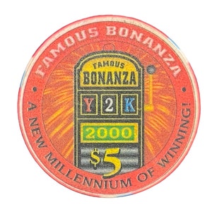 May include: Red casino chip with a slot machine graphic. The slot machine has the words "Famous Bonanza" on it. The chip says "A New Millennium of Winning!" and "$5".