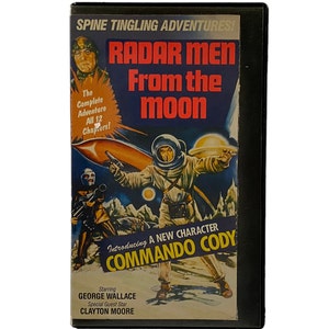 May include: A vintage VHS tape for "Radar Men From the Moon" with a retro sci-fi illustration. The cover features an astronaut, a rocket, and the text "Introducing A New Character Commando Cody". Starring George Wallace and Clayton Moore.