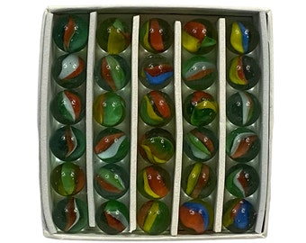 Könnte beinhalten: Eine Schachtel mit 36 bunten Glasmurmeln. Die Murmeln sind in Reihen und Spalten angeordnet, und jede Murmel hat ein anderes Farbmuster. Die Murmeln sind grün, rot, gelb, blau und weiß.