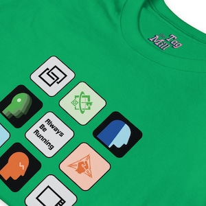 May include: A green t-shirt with a crew neck, displaying a series of colourful square graphics and the text "Always Be Running." The logo "the Tag Mill" is visible on the upper right. The graphics include geometric shapes and stylized human profiles.