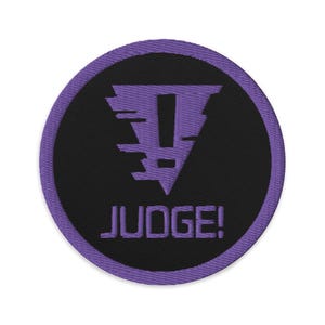 May include: Purple and black embroidered patch with a stylized exclamation point inside a triangle and the word "JUDGE!" below.