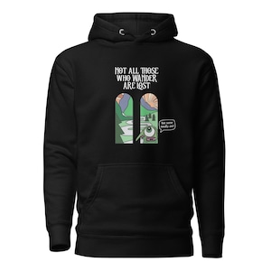May include: Black hooded sweatshirt with a front graphic. The graphic features the text "NOT ALL THOSE WHO WANDER ARE LOST" above a cartoon illustration of a landscape scene with an eye and the text "but some totally are!"