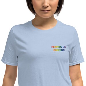 Always Be Running-geborduurd T-shirt in regenboogkleuren | Netrunner Pride, ringgesponnen katoen uniseks | Witte, blauwe en zwarte Netrunner-cadeaumerchandise