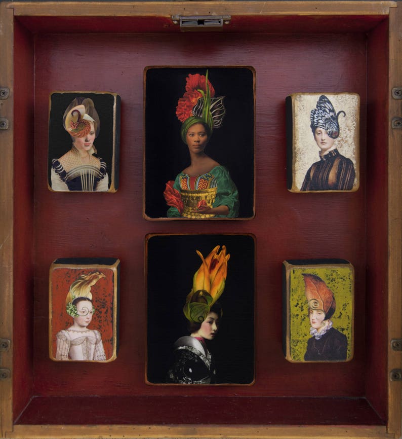 May include: A wooden box containing six framed images of women wearing elaborate headdresses. Each image has a different background colour and features a unique headdress design.