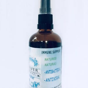 May include: A brown glass bottle with a black spray top and a white label that reads "IMMUNE SUPPORT", "NATURES NATURAL:", "ANTIBACTERIAL", "ANTIVIRAL", "Keep out of the direct sunlight", and "Store in a cool dark place".