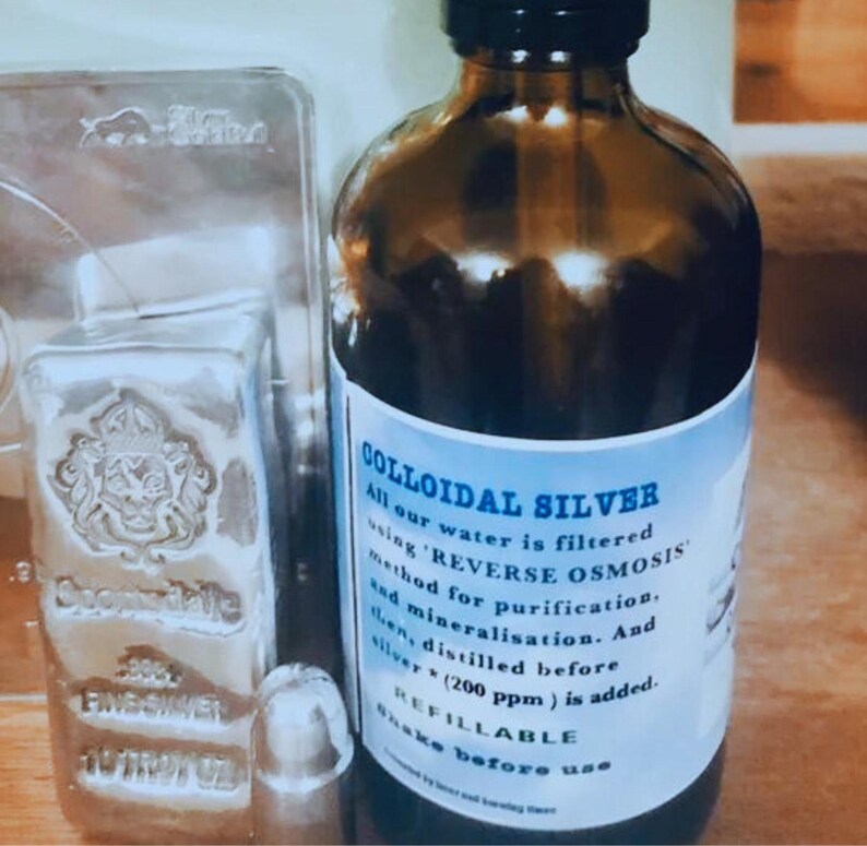 May include: A brown glass bottle with a white label that reads "COLLOIDAL SILVER". The label explains that the water is filtered using "REVERSE OSMOSIS" and that the bottle is refillable.