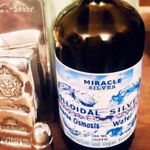 May include: A brown glass bottle with a white label that reads "Miracle Silver Colloidal Silver Reverse Osmosis Water 100 ML 200PPM Vegetarian and vegan friendly".