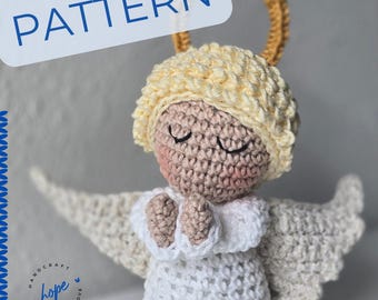 May include: Crocheted angel doll with closed eyes, praying hands, and wings. The doll has a light skin tone, a white dress, and a halo. The word "PATTERN" is in a blue box above the doll. The text "HANDCRAFT made with love" is on the bottom left.