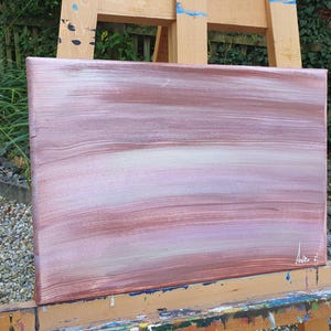 May include: Abstract painting on canvas with horizontal brushstrokes in shades of pink, white, and brown. The painting is signed in the bottom right corner.