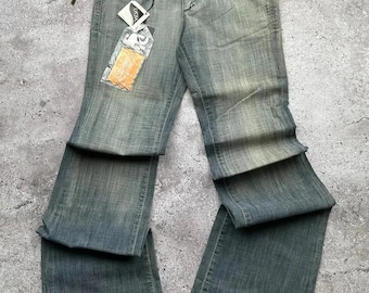 May include: A pair of light blue denim jeans with a wide leg and a faded look. The jeans have a brown leather tag with the word "JAG" on it.