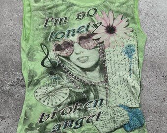 May include: Green sleeveless shirt with a graphic print of a woman with sunglasses and a flower. The text "I'm so lonely & broken angel" is printed on the shirt.