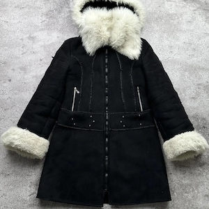 Könnte beinhalten: Ein schwarzer Mantel mit Kunstfellfutter, einer weißen Kunstfellkapuze und -manschetten. Der Mantel hat einen Reißverschluss und dekorative Nähte.