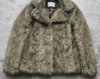 May include: A faux fur jacket in shades of brown and gray. The jacket has a wide collar, button closures, and a textured appearance. The garment is designed for warmth and style.