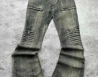 May include: A pair of dark wash denim jeans with a wide leg and a distressed look. The jeans have multiple pockets and a zipper fly.