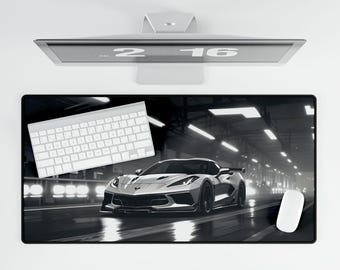 Peut inclure: Un tapis de souris noir et blanc avec une voiture de sport blanche sur une route sombre. La voiture est nette et la route est floue. Le tapis de souris est rectangulaire et a une surface lisse.