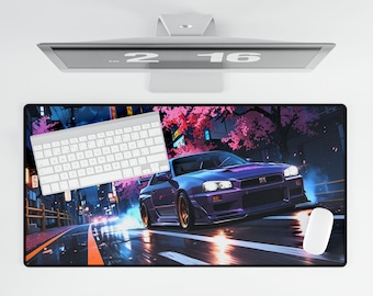 May include: A rectangular mouse pad featuring a purple sports car racing down a wet street at night. A white keyboard and mouse are on the pad. The background shows a city with cherry blossom trees.