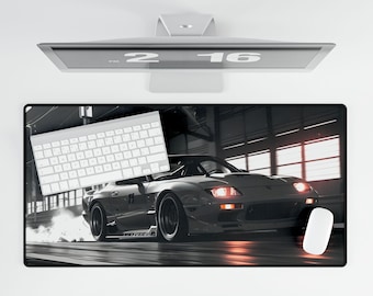 May include: A black and white photo of a silver sports car driving on a race track. The car has red taillights and a black spoiler. The car is in motion and there is a trail of smoke behind it.