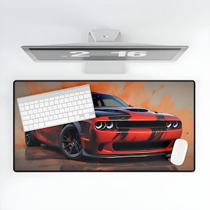 May include: A red and black Dodge Challenger muscle car with a black racing stripe on a orange and brown background. The car is on a desk mat with a white keyboard and a white mouse.