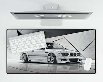 May include: A white BMW with black accents on a black and white geometric design mousepad. The mousepad is on a white surface. A white keyboard is on the left side of the mousepad. A white computer monitor is in the background.