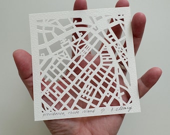 May include: A white paper cutout of the city of Providence, Rhode Island. The map is intricate and detailed, showing the streets and buildings of the city. The text "Providence, Rhode Island ||| K. O'Leary" is written in black ink at the bottom of the map.