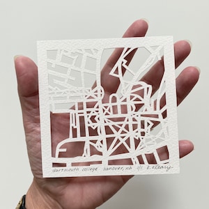 May include: A white paper cutout of a map of Dartmouth College in Hanover, New Hampshire. The map is signed "K. O'Leary".