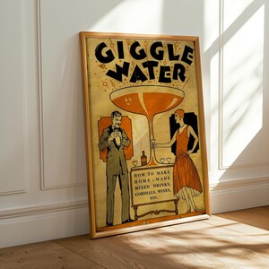 Op de afbeelding: Een ingelijste poster in vintage-stijl met de woorden "GIGGLE WATER" in grote zwarte letters. De poster bevat illustraties van een man en een vrouw, en de tekst "HOW TO MAKE HOME MADE MIXED DRINKS, CORDIALS, WINES, ETC."