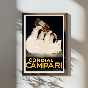 Pu&ograve; includere: Una pubblicit&agrave; vintage incorniciata per Cordial Campari. L'opera presenta un orso polare bianco che tiene in mano una bottiglia di Campari, con la bevanda che si versa nella sua bocca. Il testo "Cordial Campari" &egrave; in lettere gialle.