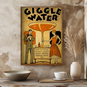Op de afbeelding: Vintage poster met de woorden "GIGGLE WATER" in zwart en oranje. De poster toont illustraties van een man en een vrouw in kleding uit de jaren 1920, met een groot cocktailglas. Tekst eronder luidt "HOW TO MAKE HOME - MADE MIXED DRINKS, CORDIALS, WINES, ETC."