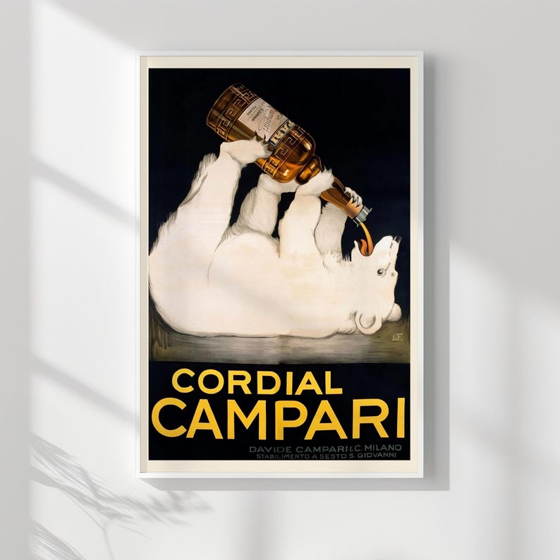 Pu&ograve; includere: Stampa di poster vintage incorniciata con un orso polare che versa una bottiglia di Cordial Campari. L'orso &egrave; bianco su sfondo scuro, con il nome del marchio in grandi lettere gialle.