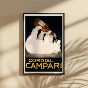 Pu&ograve; includere: Una pubblicit&agrave; vintage incorniciata per Cordial Campari. Il poster presenta un orso polare bianco reclinato che beve da una bottiglia. La bottiglia versa un liquido marrone nella bocca dell'orso. Il testo "Cordial Campari" &egrave; in lettere d'oro.