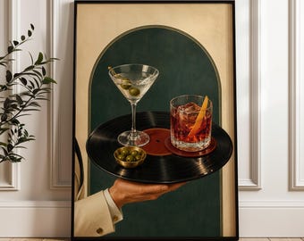 Peut inclure: Une impression d'art mural encadrée montrant une main tenant un disque vinyle noir servant de plateau. Sur le disque se trouvent un verre à martini avec des olives, un petit bol doré d'olives et un verre à cocktail ambré avec un zeste d'orange.