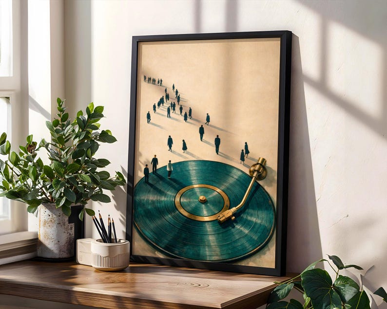 May include: A framed art print featuring a teal vinyl record with a gold tone center and arm. Silhouetted figures walk towards the record. The artwork is displayed on a wooden surface with a potted plant and a pencil holder.