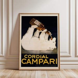 Pu&ograve; includere: Poster vintage incorniciato per Cordial Campari. L'opera presenta un orso polare bianco che beve da una bottiglia. Il poster ha uno sfondo nero con scritte dorate e una cornice in legno marrone.