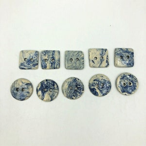 Pu&ograve; includere: Una collezione di dieci bottoni in ceramica, di forma quadrata e rotonda. I bottoni presentano un motivo marmorizzato blu e crema. Ogni bottone ha due fori per cucire.