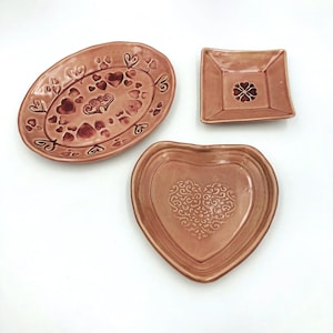 Valentine ring dish in pink with textured heart designs, some with ruby red accents