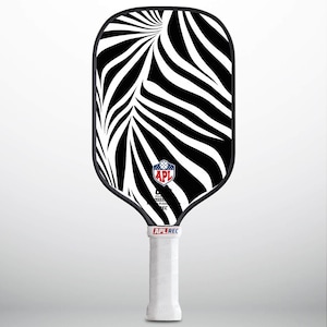 Könnte beinhalten: Ein schwarz-weißes Pickleball-Schläger mit Zebra-Muster, schwarzem Griff und dem Schriftzug "APL REC" in weißen Buchstaben. Der Schläger hat ein schwarz-weißes Logo mit dem Schriftzug "APL" in roten Buchstaben.