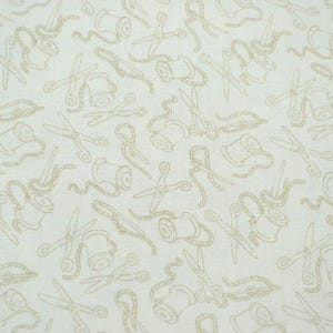 May include: Off-white fabric with a repeating pattern of tan-colored sewing tools. The design includes scissors, spools of thread, and measuring tapes, creating a craft-themed textile.