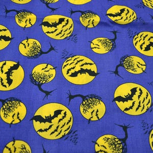 May include: A blue fabric with a Halloween-themed pattern. The design features yellow full moons with black bats and trees. The bats are in flight, and the trees have a spooky, twisted appearance. This fabric is suitable for seasonal crafts.