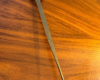 May include: A vintage brass candle snuffer with a horse head design at the top. The snuffer has a long, slender handle and a conical base. The candle accessory is designed to extinguish candles safely.