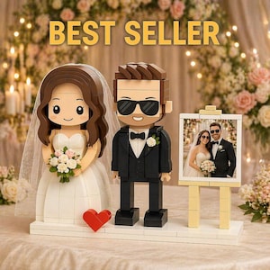 May include: A Lego wedding set with bride and groom figures, a red heart, and a framed photo of a couple. The bride wears a white dress and veil, holding a bouquet. The groom is in a tuxedo. The words "BEST SELLER" are at the top.