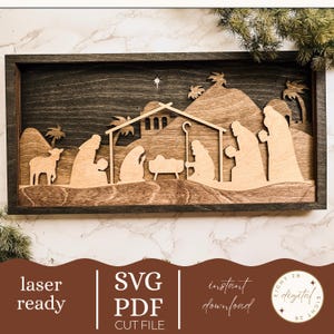 Può includere: Un presepe in legno in una cornice tinta scura. Il design a strati presenta sagome della Sacra Famiglia, dei Re Magi e di un agnello, con una stella sopra la stalla. Sono visibili anche le parole "laser ready", "SVG PDF CUT FILE" e "instant download".