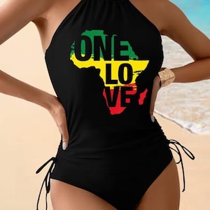 May include: Black halter swimsuit featuring the African continent in green, yellow, and red, with the words "ONE LOVE" in black. The swimsuit has adjustable side ties and a halter neck design.