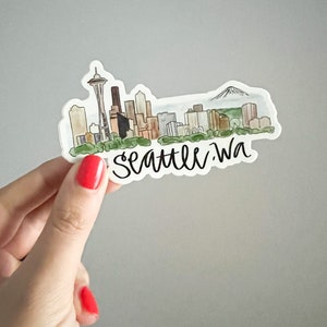 May include: A watercolor illustration of the Seattle skyline with the Space Needle, Mount Rainier, and the text "Seattle, WA".