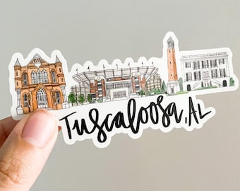Puede incluir: Una pegatina con una ilustración de acuarela del campus de la Universidad de Alabama en Tuscaloosa, Alabama. La pegatina incluye los edificios icónicos de la universidad, incluyendo el estadio, la torre del campanario y la mansión del presidente. La pegatina también incluye el texto "Tuscaloosa, AL".