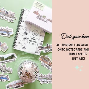 May include: A collection of stickers featuring city skylines, including New York, Cincinnati, Memphis, Atlanta, and San Francisco. The stickers are arranged on a green surface with a silver disco ball and a spiral notebook with a city skyline design. The notebook has the text "SPIRAL NOTEBOOK" on the cover. The text "Did you know? ALL DESIGNS CAN ALSO BE MADE ONTO NOTECARDS AND PRINTS! DON'T SEE IT? JUST ASK!" is written on a pink background.