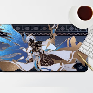 Op de afbeelding: Een rechthoekige bureaumat met een gedetailleerde illustratie van een personage met blauwe vleugels en gouden accenten. De mat heeft een donkerblauwe achtergrond met een decoratieve rand. Een wit toetsenbord, een gouden pen en een kopje koffie zijn ook zichtbaar.